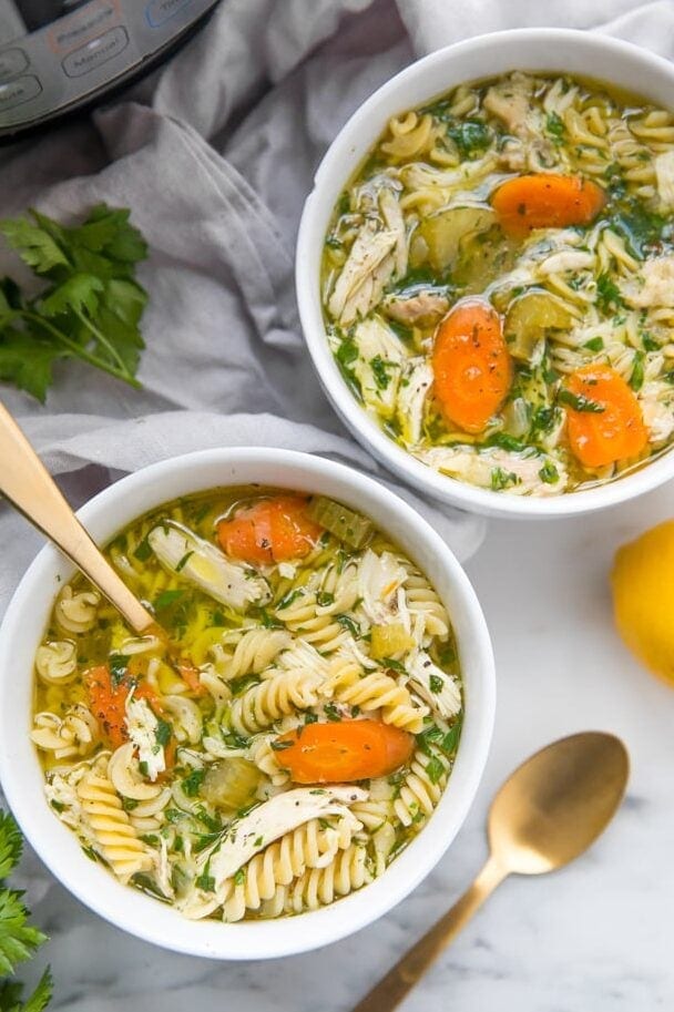 Instant Pot gluten free chicken noodle soup in bowls with Instant Pot in background