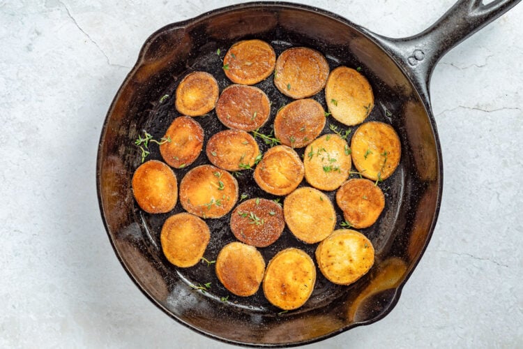 Fried potatoes with fresh thyme leaves sprinkled over the top.