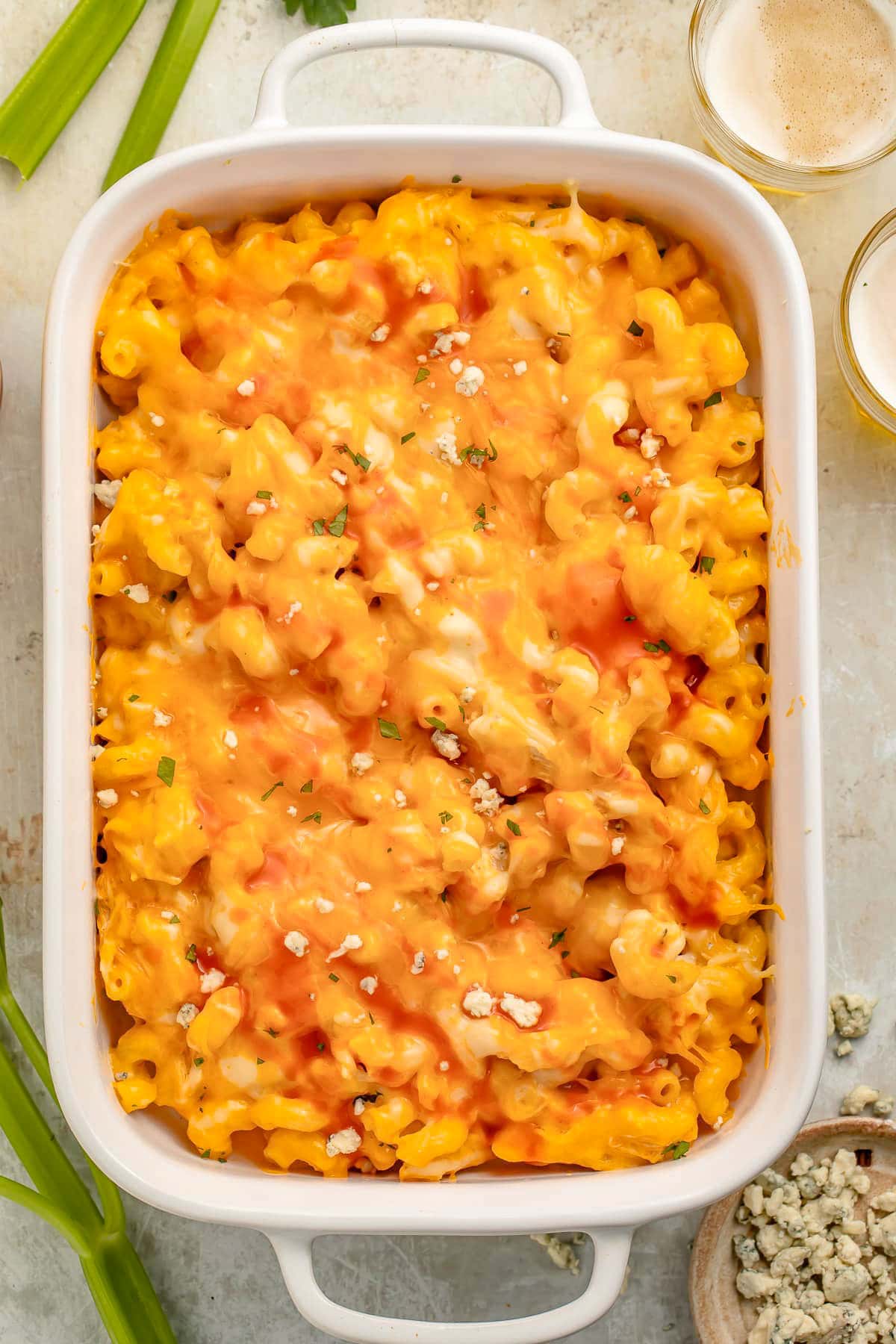 Overhead photo of a large white rectangular casserole dish holding a baked buffalo chicken mac & cheese.