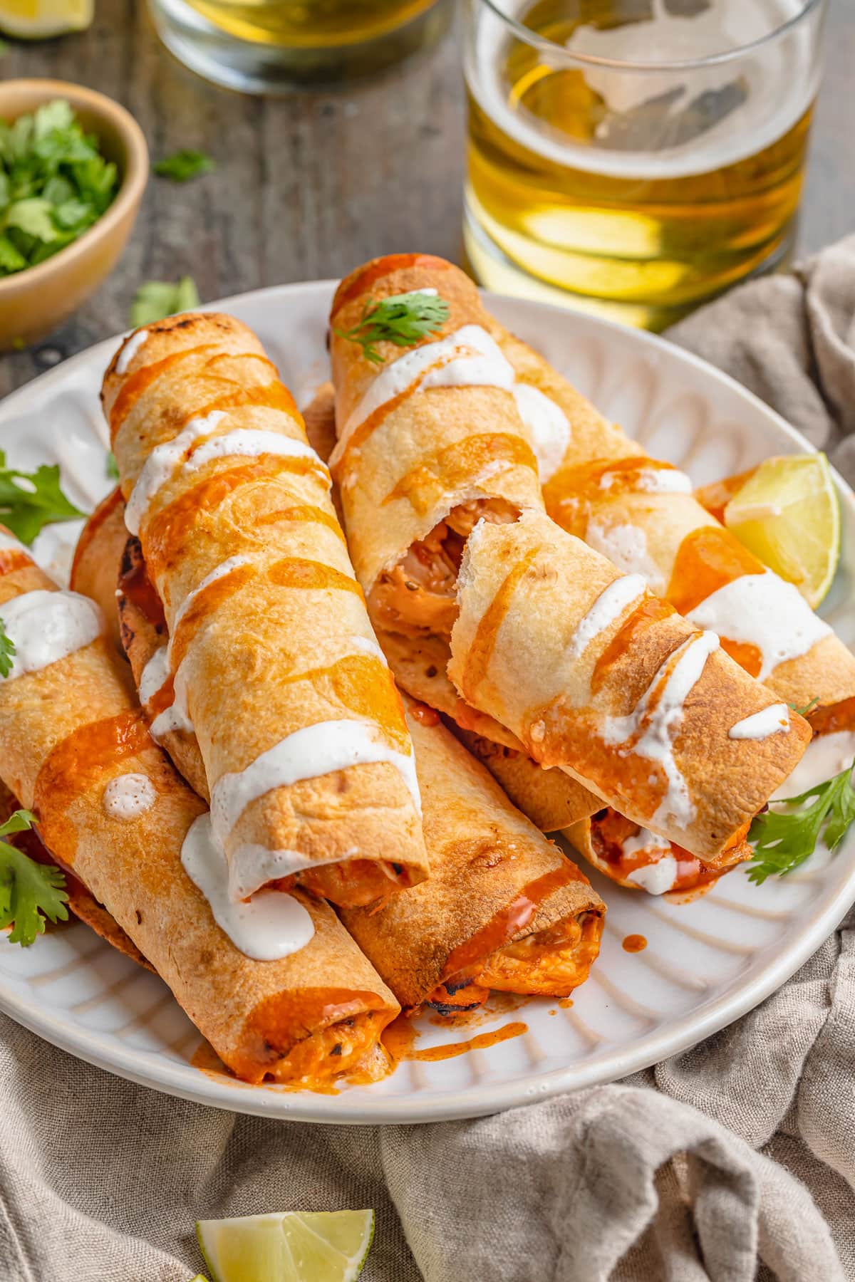 5-ingredient air fryer flautas stacked on a plate and topped with queso.