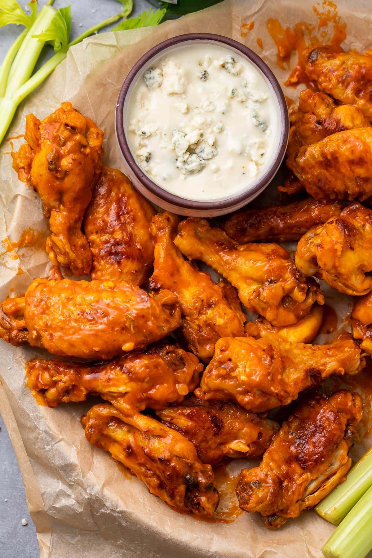 A plate of buffalo orange chicken wings cooked in an Instant Pot and plated with a small ramekin of ranch dressing.