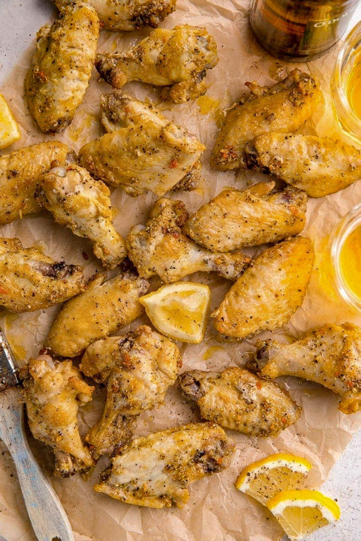 Lemon pepper seasoned chicken wings on a baking sheet lined with parchment paper.