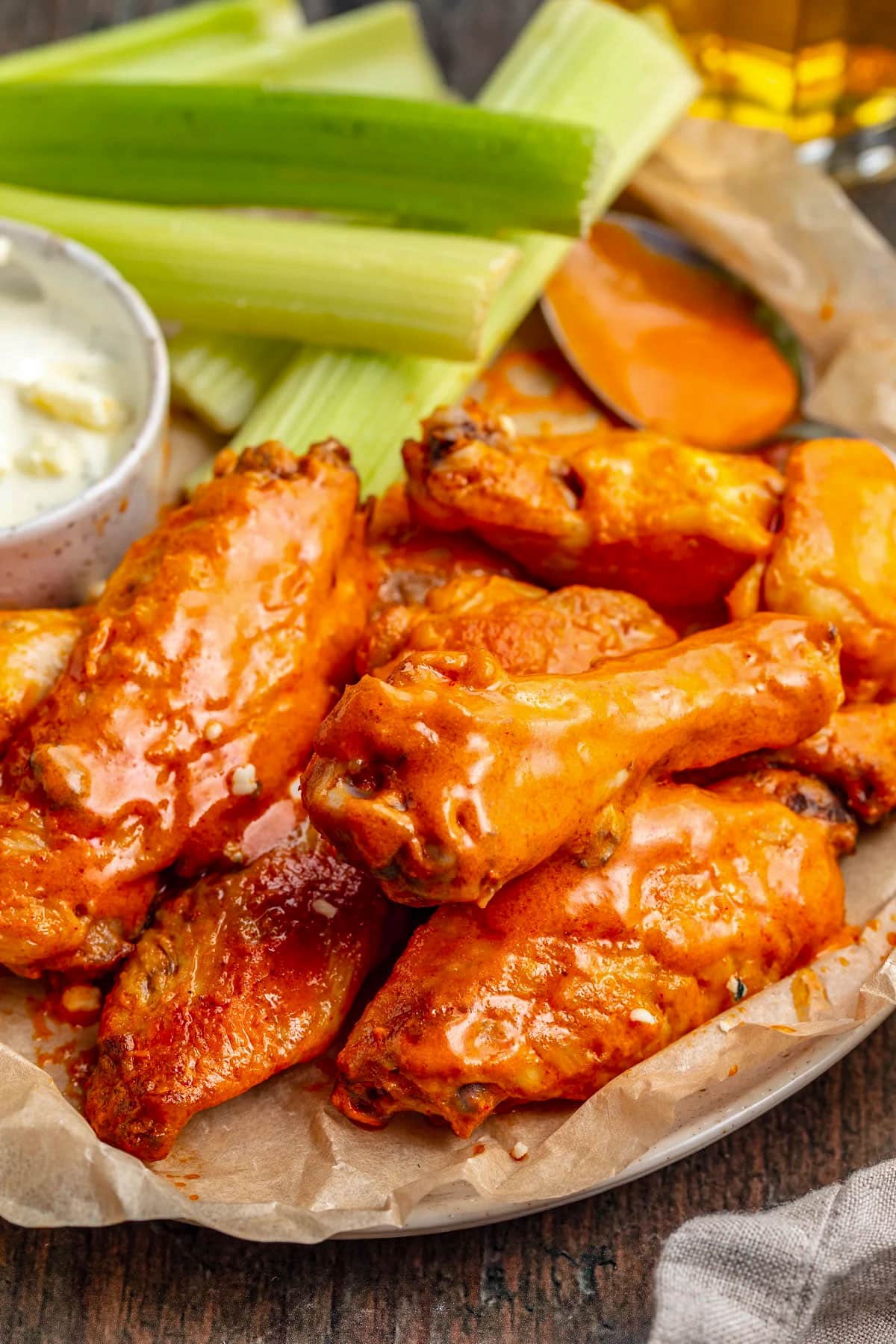 Buffalo chicken wings cooked sous vide on a platter with celery sticks and blue cheese dressing.