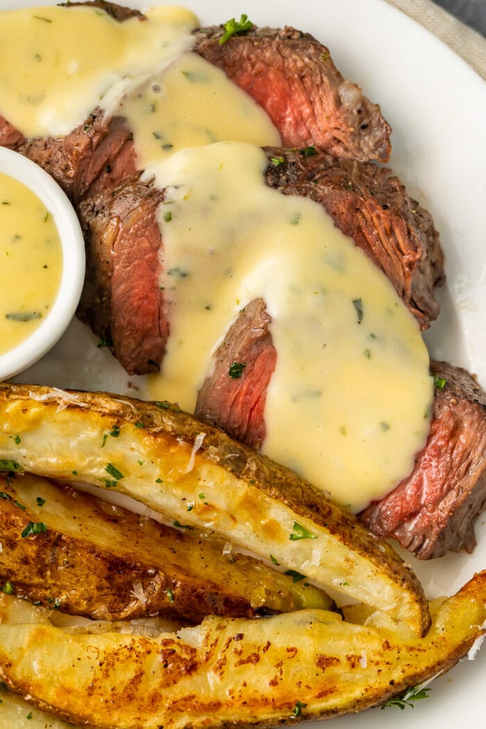 Sheet pan steak and fries with microwave bearnaise sauce on a white plate