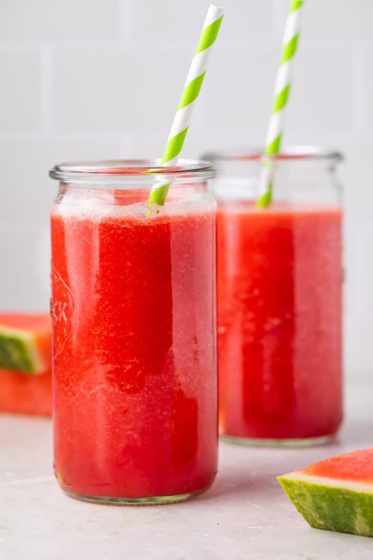 Two glasses of watermelon juice with green and white striped straws