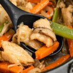 chicken chop suey in a pan with a spoon