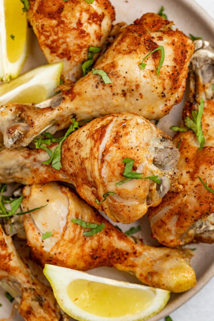 instant pot chicken legs on a plate with lemon slices