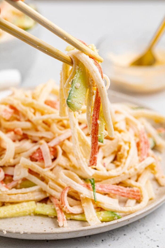 kani salad being lifted off a plate with chopsticks