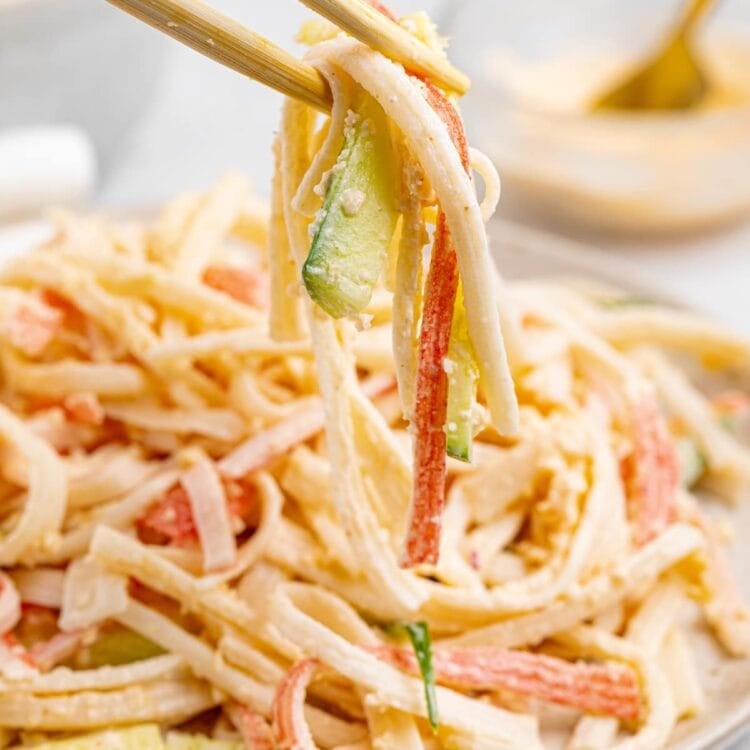 kani salad being lifted off a plate with chopsticks