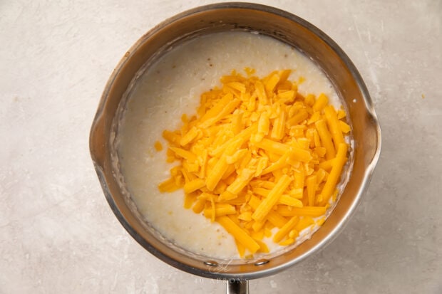 Grits with shredded cheese in saucepan