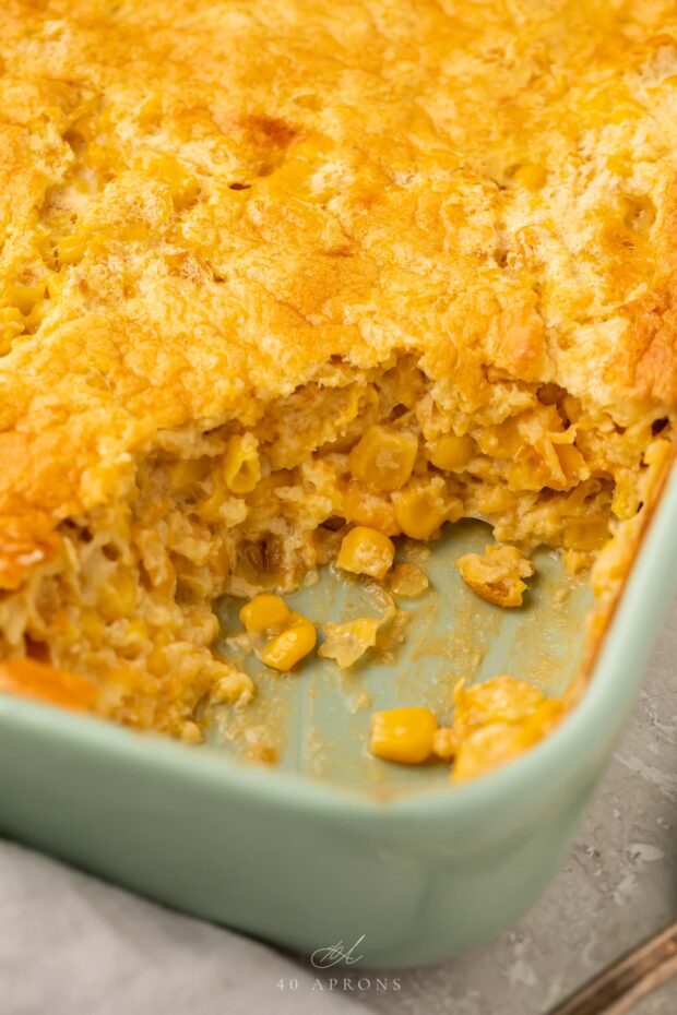 Angled photo of corn souffle with a scoop missing from the corner to show the inside of the souffle