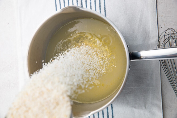 Pouring grits into saucepan
