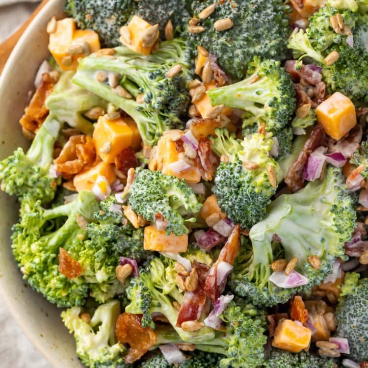 Keto broccoli salad in a large bowl on a table next to a wooden spoon