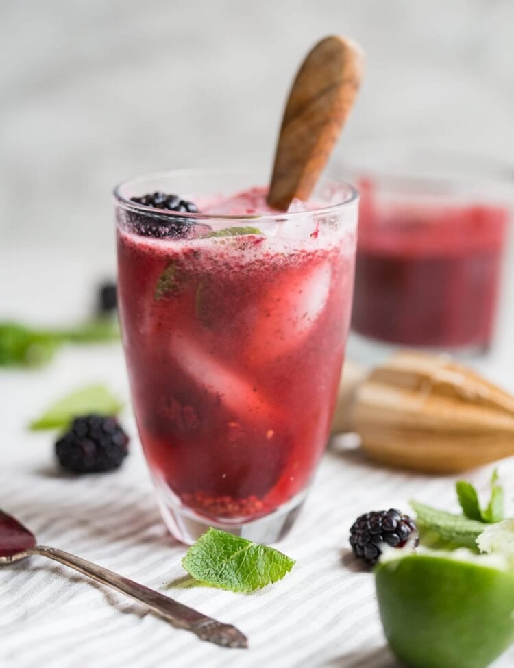 Paleo blackberry mint cocktail in a glass with a muddler
