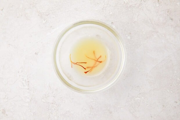 Chicken stock and saffron in a small glass bowl