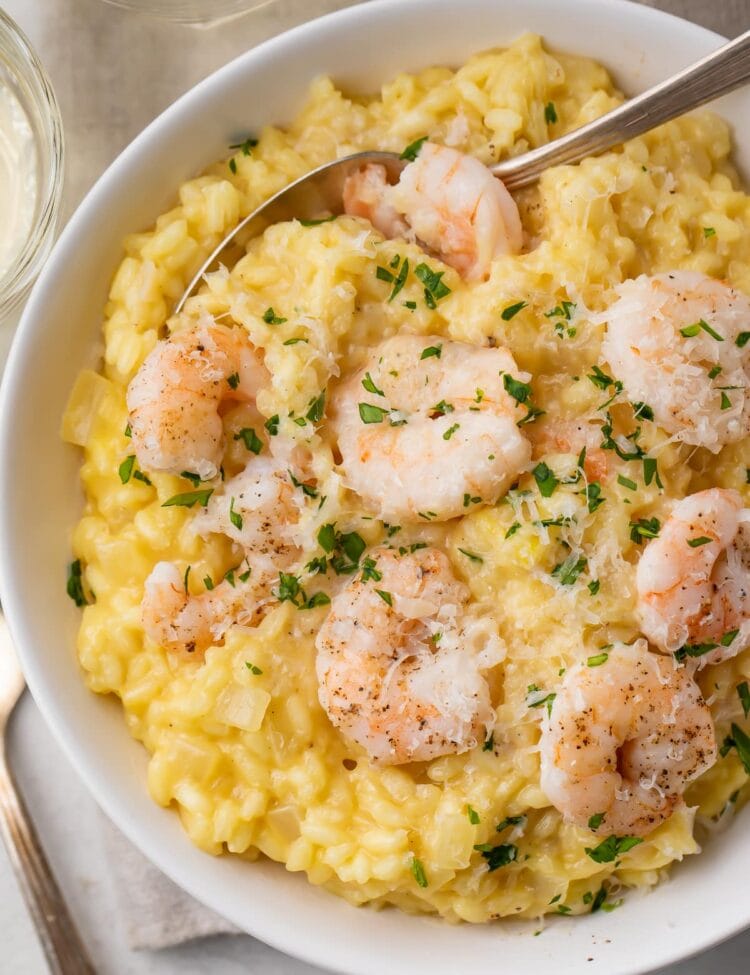Shrimp risotto in a large white bowl with a fork