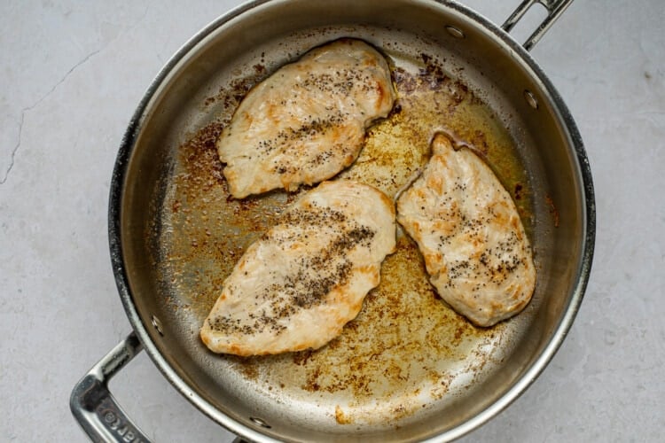Chicken in butter in a large silver pan