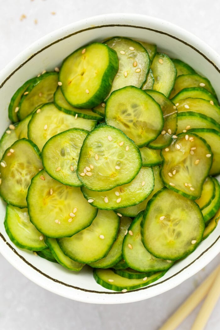 overhead image of japanese cucumber salad in a bowl with sesame seeds