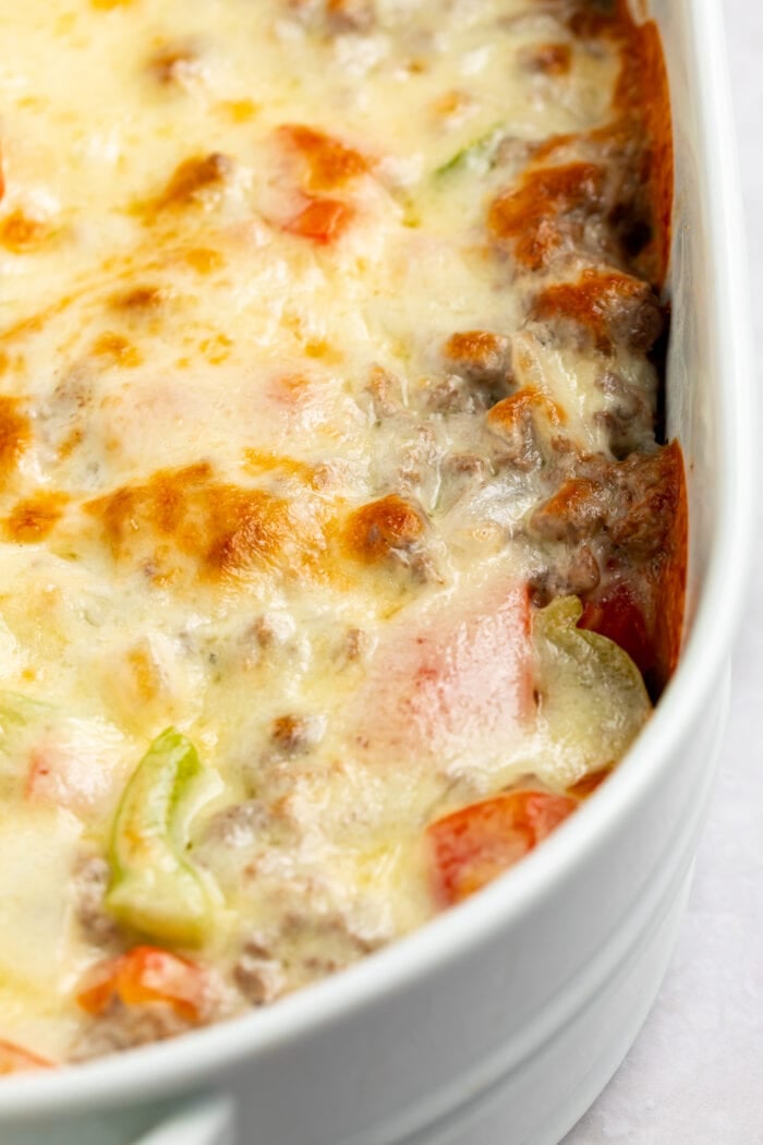 close up image of philly cheesesteak casserole in the baking dish