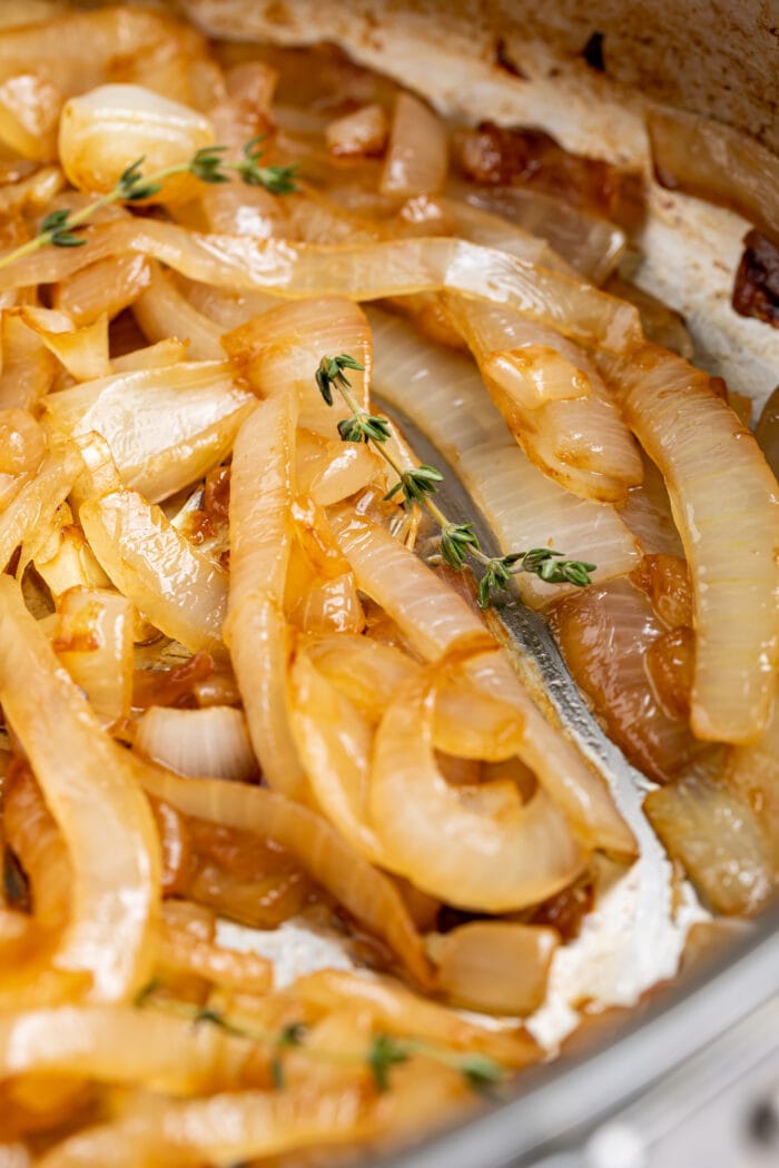 close up image of sauteed onions with fresh thyme