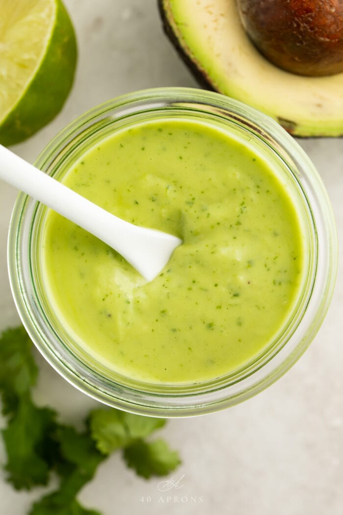 Overhead view of avocado dressing in a glass jar