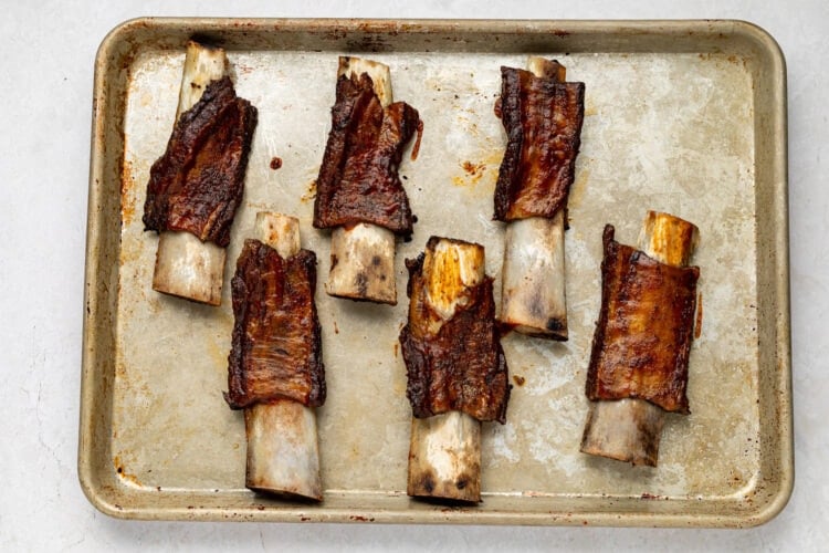 Caramelized BBQ beef back ribs on baking sheet.