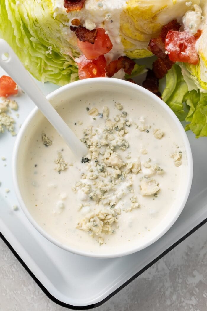 Blue cheese dressing in a small bowl next to salad
