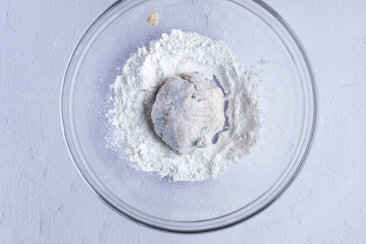 Chicken ball in flour in medium glass bowl