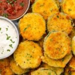 Fried zucchini next to small cups of marinara and parmesan ranch