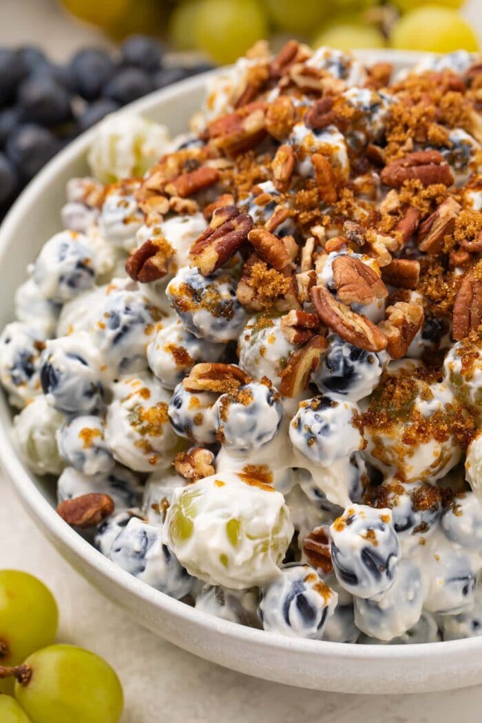 Creamy grape salad topped with pecans and brown sugar