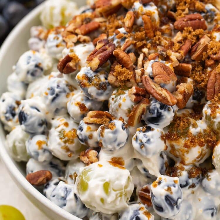 Creamy grape salad topped with pecans and brown sugar