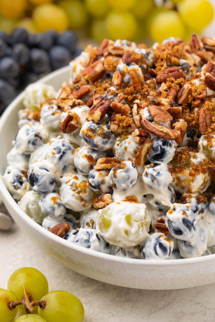 Creamy grape salad topped with pecans and brown sugar