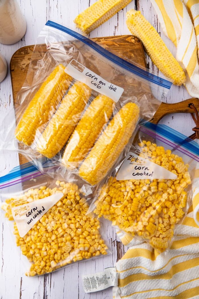 Corn cobs and corn kernels in freezer bags on a wooden table