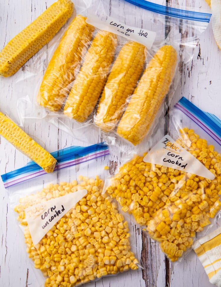 Corn cobs and corn kernels in freezer bags on a wooden table