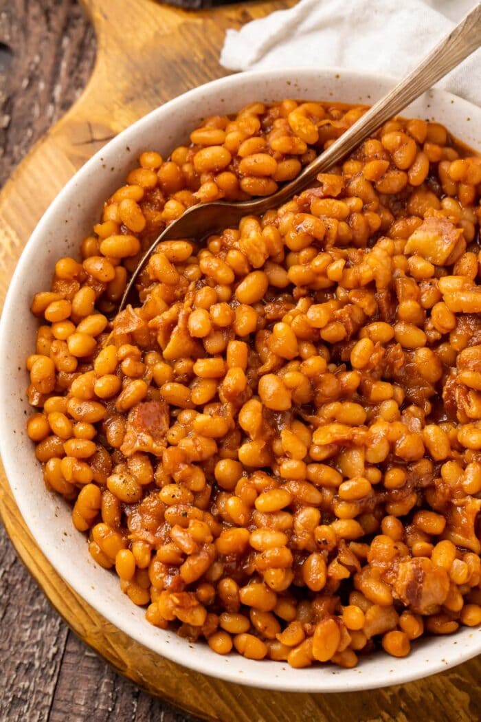 Overhead photo of Instant Pot baked beans in a white bowl on a wooden board