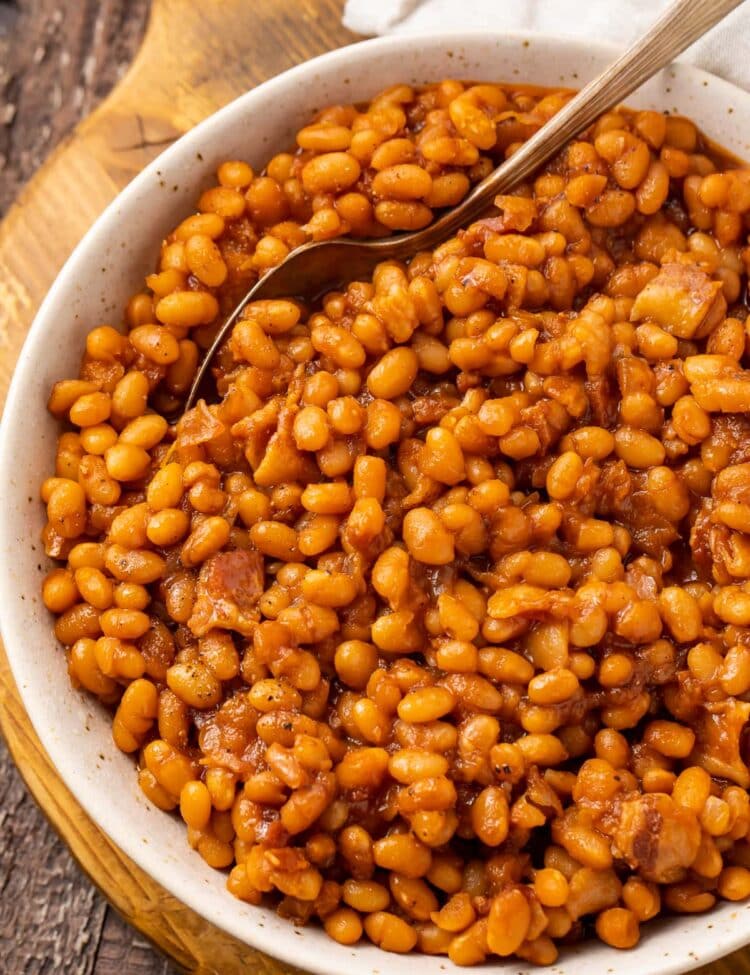 Overhead photo of Instant Pot baked beans in a white bowl on a wooden board