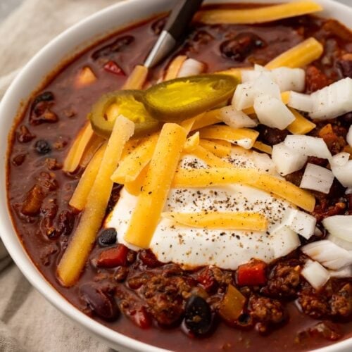 Angled photo of nourishing slow cooker chili in a white bowl