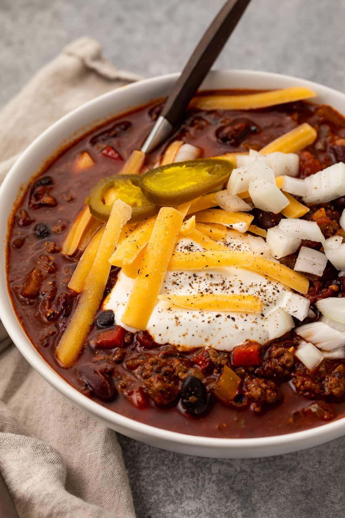 Angled photo of nourishing slow cooker chili in a white bowl