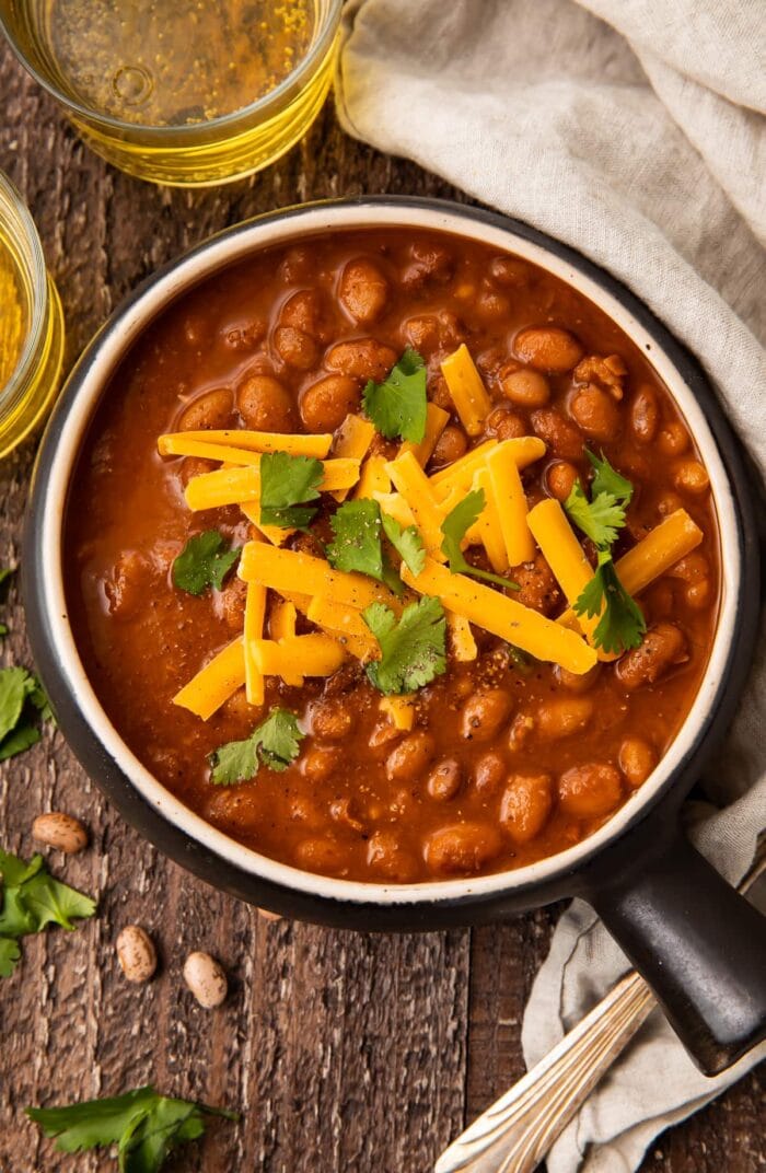 Overhead photo of ranch style beans in a black bowl on a wooden table