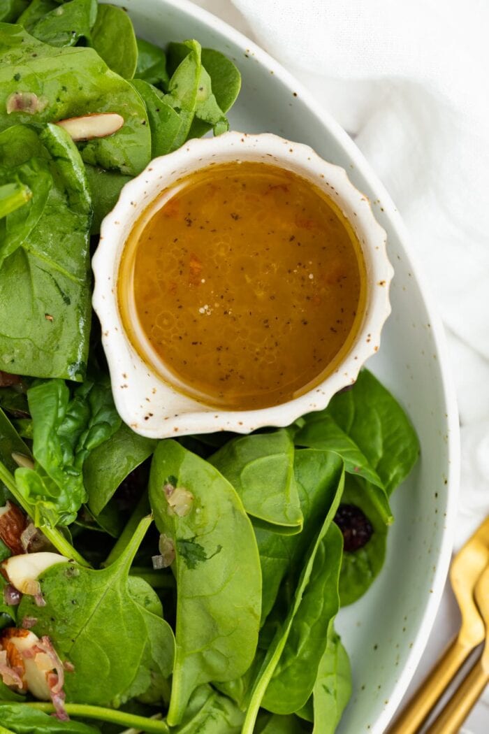 hot bacon dressing in a small dish next to salad