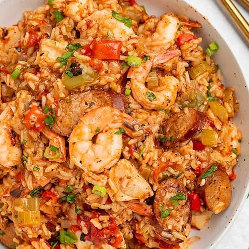 Overhead photo of a large white bowl holding Instant Pot jambalaya with rice, shrimp, sausage, and veggies.