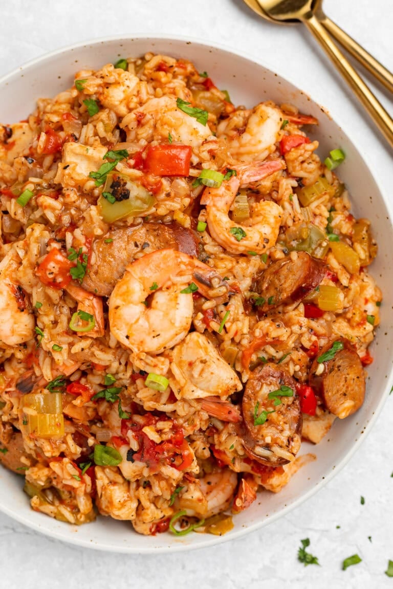 Overhead photo of a large white bowl holding Instant Pot jambalaya with rice, shrimp, sausage, and veggies.