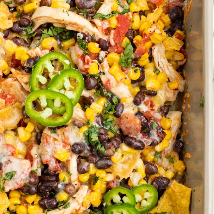 Overhead view of Mexican chicken casserole with tortilla chips, chicken, black beans, and corn, topped with cheese and jalapenos.