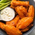 Air fryer chicken wings and celery on a platter with blue cheese dressing