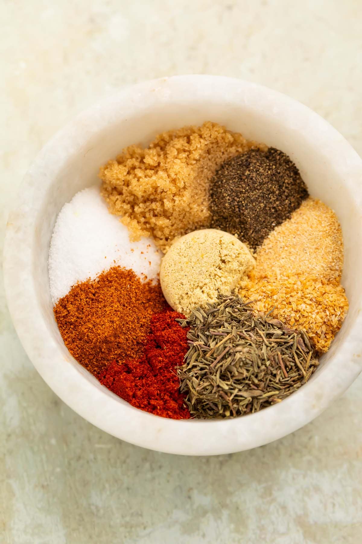 8 spices for homemade pork chop seasoning in a small bowl.