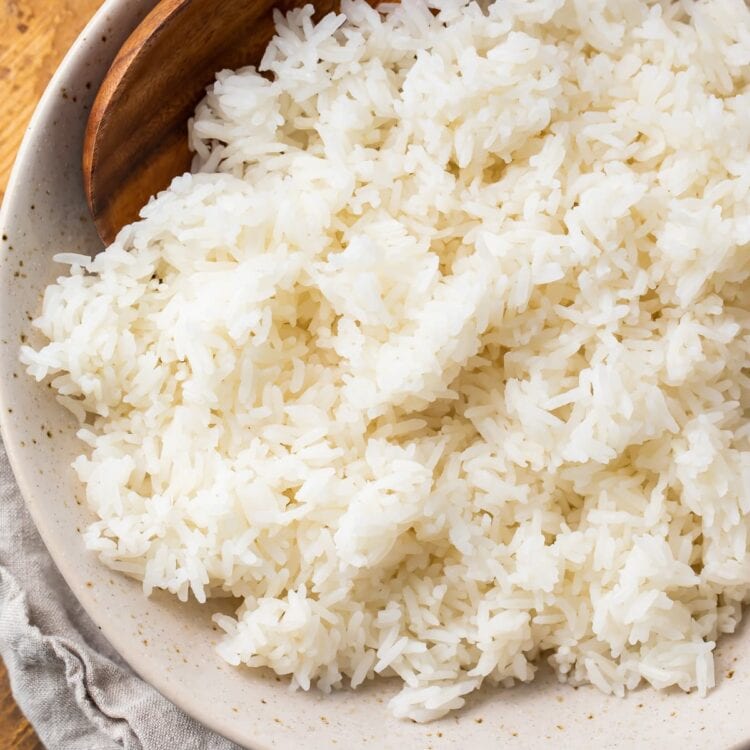 Overhead photo of Instant Pot jasmine rice in a bowl on a wooden tray with a cloth napkin