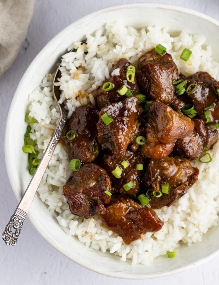 Pork adobo on top of white rice in a serving bowl