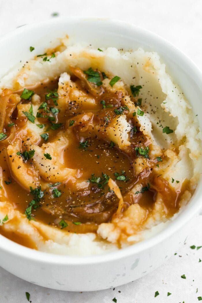 mashed potatoes with onion gravy and chopped parsley on top