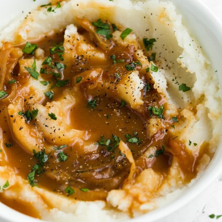 mashed potatoes with onion gravy and chopped parsley on top