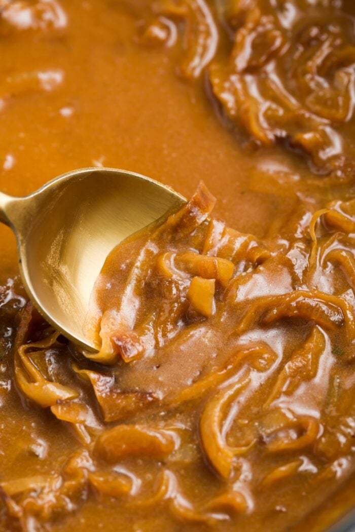 onion gravy in a saucepan with a spoon